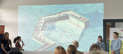 Studierende präsentieren dem Publikum per Beamer ihre Idee mit schwimmenden Inseln auf einem See