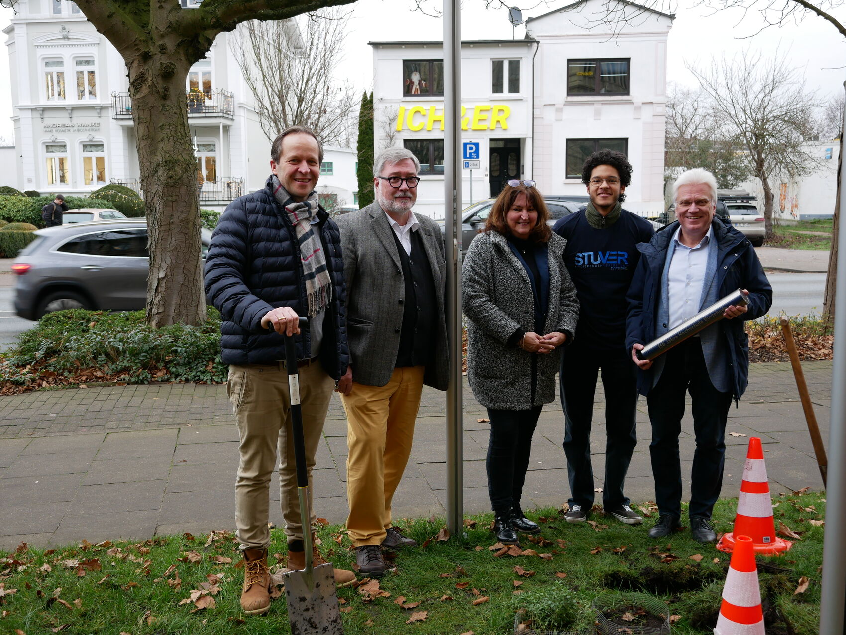 5 Personen stehen vor der Kamera, eine Person hält eine Zeitkapsel aus Metall.