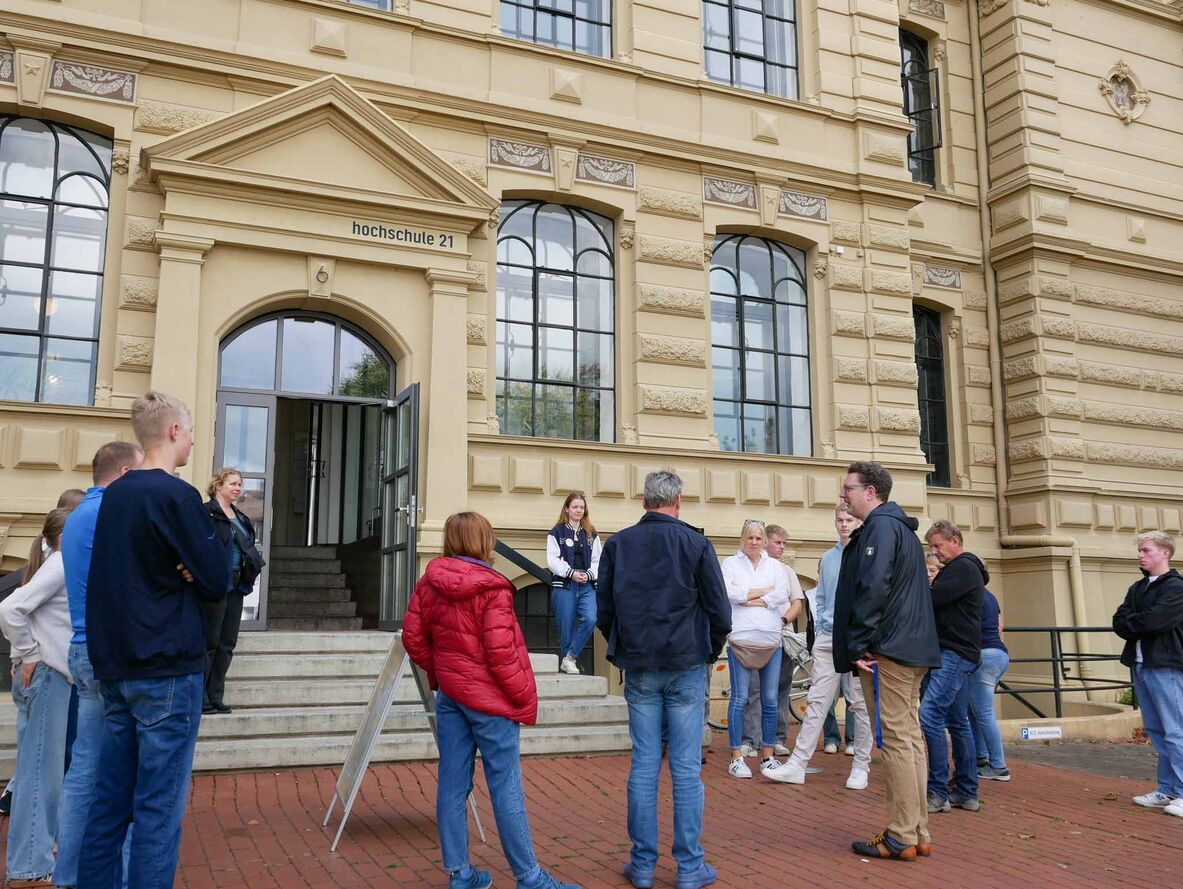 Prof. Dr.-Ing. Karsten Ley steht mit Teilnehmenden des Rundgangs vor dem Hochschulgebäude.
