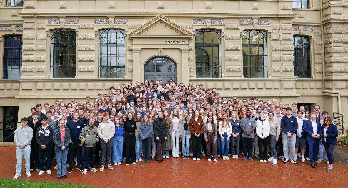 Gruppenfoto der Erstsemester 2025 der Fachbereiche Bauwesen und des Studiengangs Physiotherapie mit einigen Professorinnen und Professoren vor dem Hochschulgebäude.