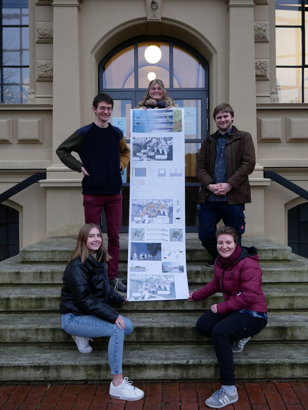 Gruppe Grau zu Grün vor dem Eingang der hochschule 21