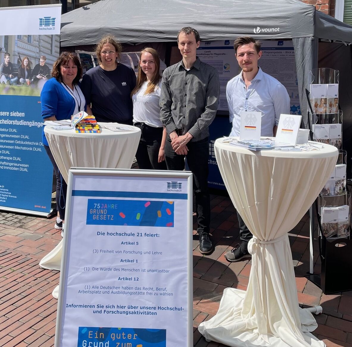 Gruppe von Hochschulangehörigen stehen am Infostand der Hochschule