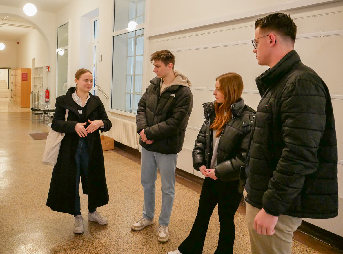 Studierende zeigen Schülerinnen und Schülern die Hochschule