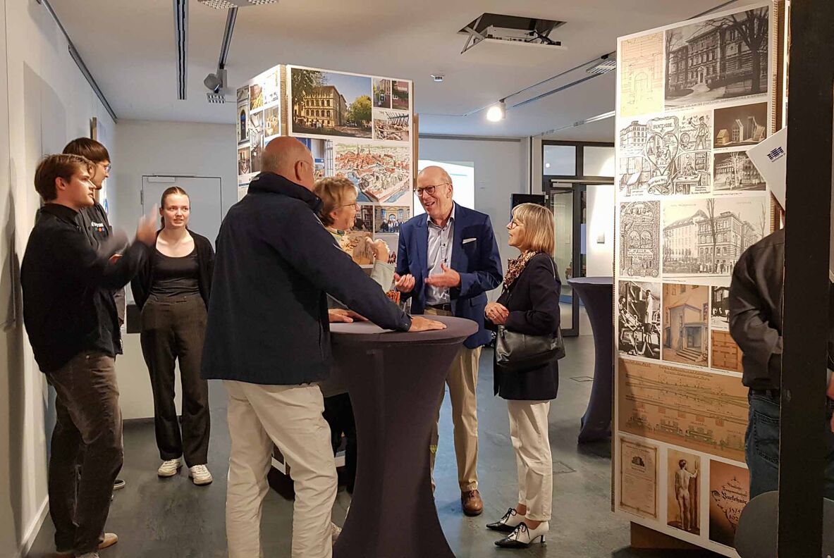Im Ausstellungsraum unterhalten sich die Gäste inmitten der Exponate.
