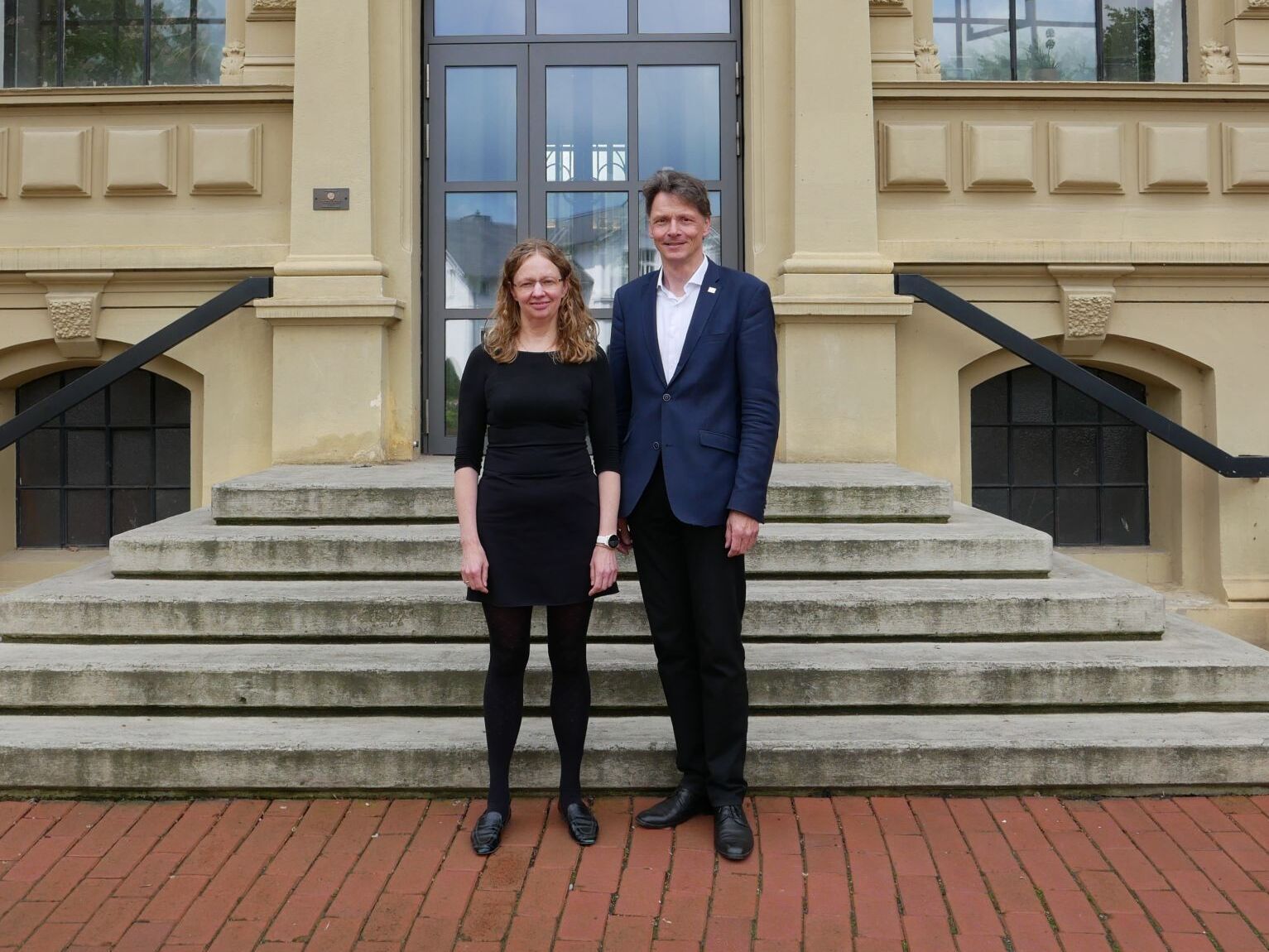 Inge Rörig-Dalgaard und Prof. Holger Stehr vor dem Gebäude der hochschule 21
