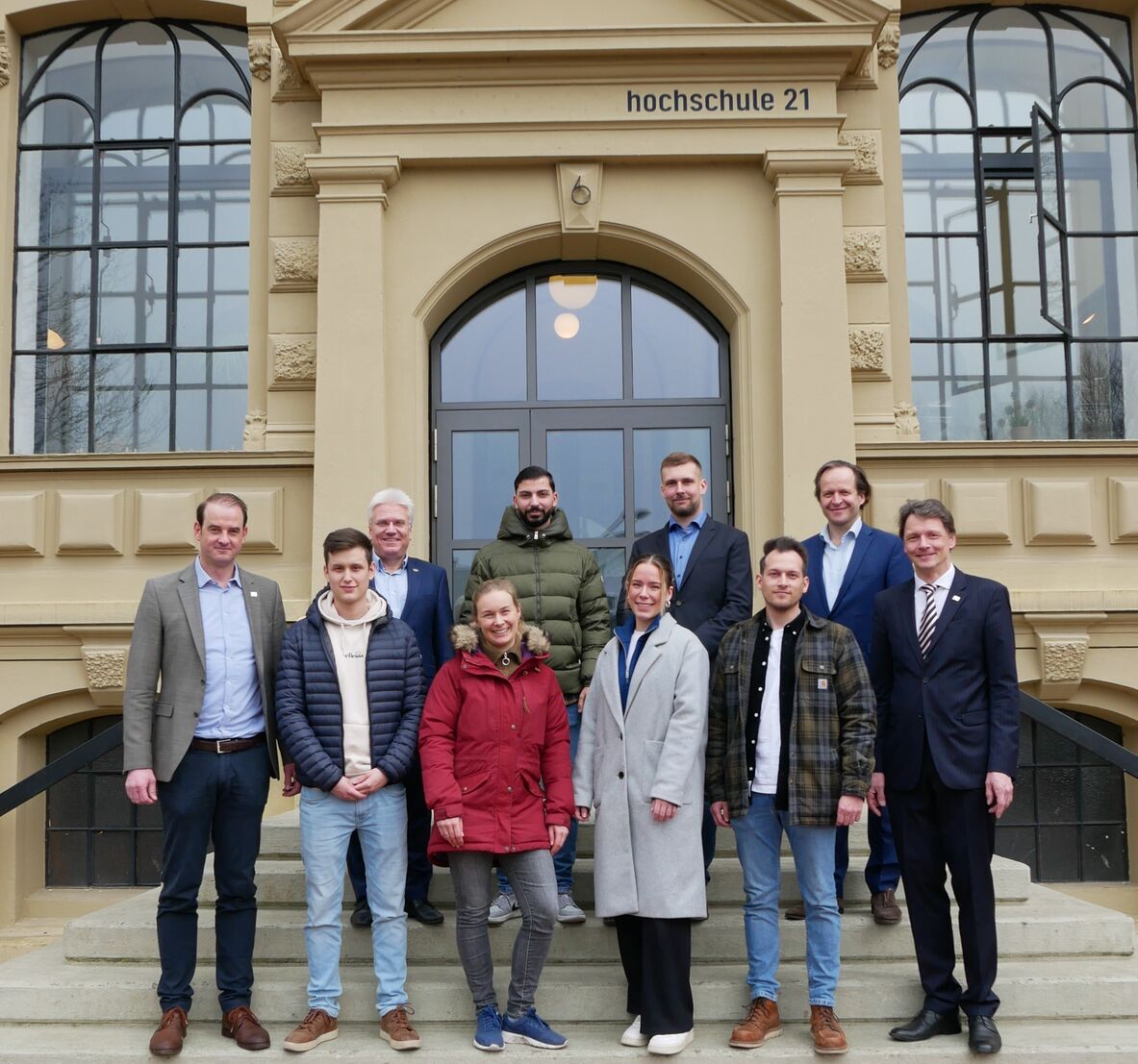 Studierende Baumaster vor dem Hochschulgebäude