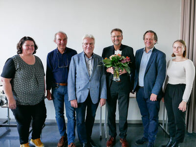 Gruppenfoto mit Wolfgang Behm mit Blumenstrauß in der Hand